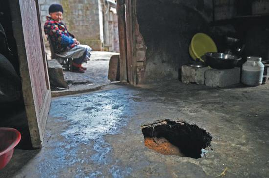 ▲彭方圆家的一处地面塌陷。这是个直径35厘米，深35厘米的圆洞。彭方圆告诉记者，这个洞最早是2014年突然出现的，用土回填过一次，3个月后再次塌陷。