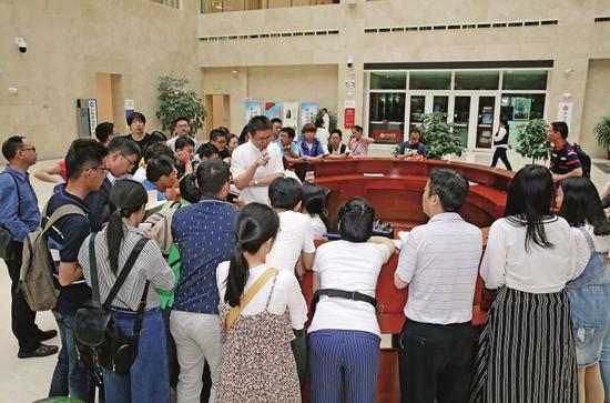 　　2018年5月，天津滨海新区行政审批中心服务大厅，引进人才联审窗口的工作人员回答外省市人才办理落户新区业务的相关咨询。图/视觉中国