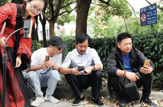 　　等候多时的网络粉丝们早已架好拍摄杆，簇拥到沈巍的身边。有的从远方带来了羽绒服，有的拎着一箱螃蟹。沈巍会把这些粉丝送给他的礼物托付给身边的助理，然后马上转过身接着面对手机屏幕，一一回答着手机里面的问候和提问。摄影/本刊记者&nbsp;董洁旭