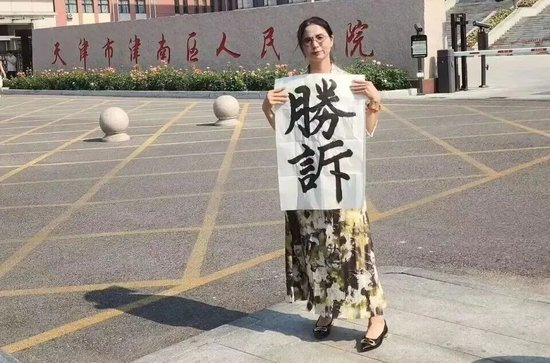 　工伤行政诉讼判决胜诉后，崔丽丽在法院门口拍摄。 受访者供图