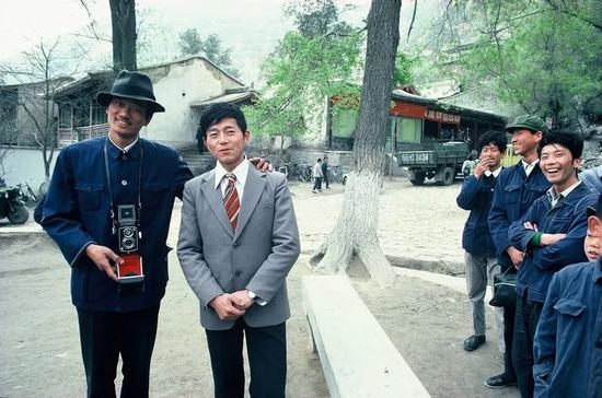△ 1979年，兰州，一名身穿西装拍照的本地男子引起围观。人们的穿着正在发生微妙的改变。
