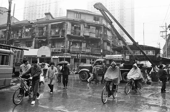 △&nbsp;1993年，上海，改造中的淮海中路，行人、脚踏车与施工车辆被雨水杂糅在一起。