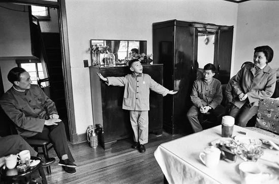 △ 1976年，上海，上海京剧团的一名成员在家中指导孩子清唱。