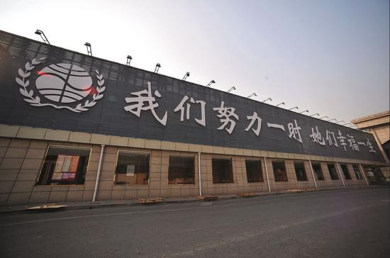  天津权健总部的一处外墙上的标语：我们努力一时 她们幸福一生。
