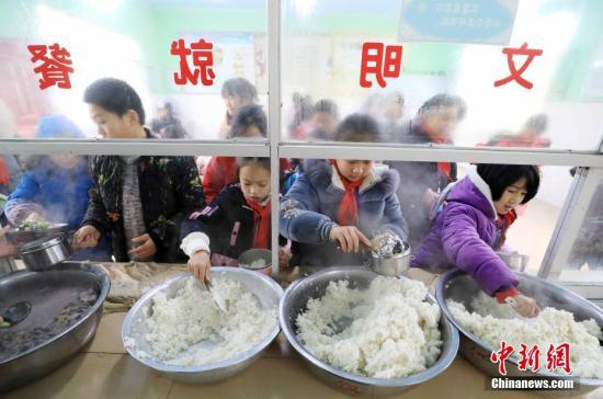 资料图：学生们按照饭量盛米饭。谭凯兴 摄