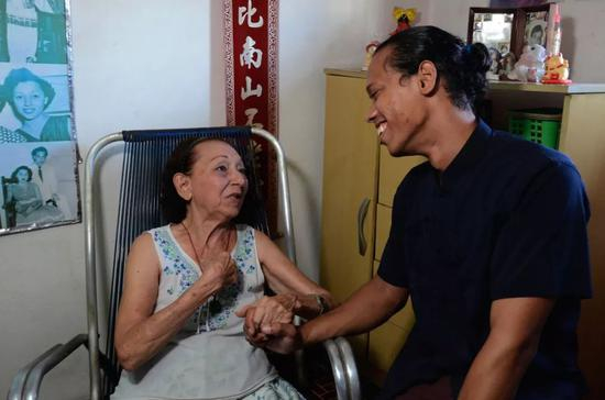 何秋兰和长孙亚米尔·方在家中聊天。新华社发（华金·埃尔南德斯摄）