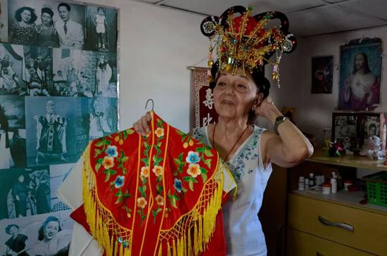  何秋兰在家中展示自己的粤剧戏服。新华社发（华金·埃尔南德斯摄）