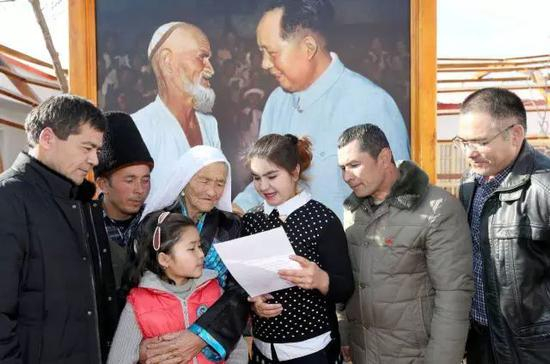 ▲&nbsp; 托乎提汗·库尔班一家人在读习近平总书记的回信。