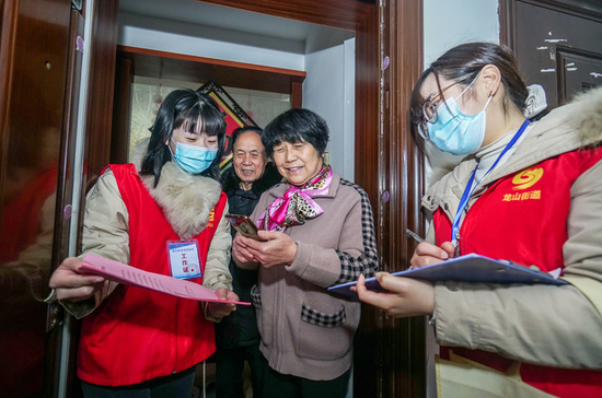 2021年12月16日，在浙江省湖州市长兴县龙山街道齐北社区，社区干部上门对辖区居民进行扫码信息登记录入，开展疫情防控排查工作。 新华社发（吴拯摄）