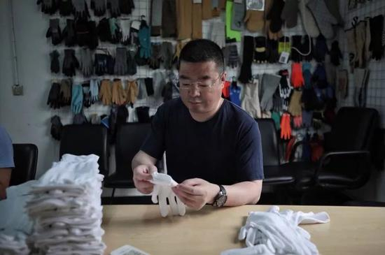 陆勇走进车间，摆弄起手套。新京报记者王嘉宁 摄