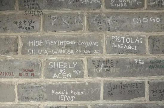  ▲长城的砖石上刻满了各国文字的涂鸦 （图viaVCG）