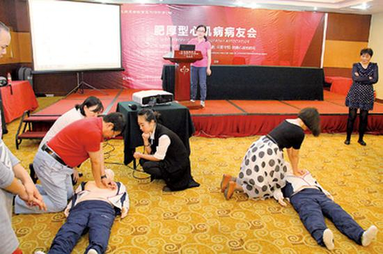 ▲病友会现场指导病友做紧急人工心肺复苏,地上为模拟人。照片均为受访者供图