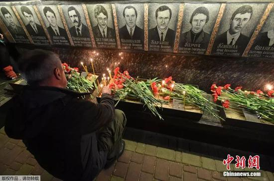 当地时间2018年4月26日，乌克兰Slavutich民众凌晨前往墓地，点烛献上鲜花悼念在清理切尔诺贝利核事故中死亡的“清理人”。