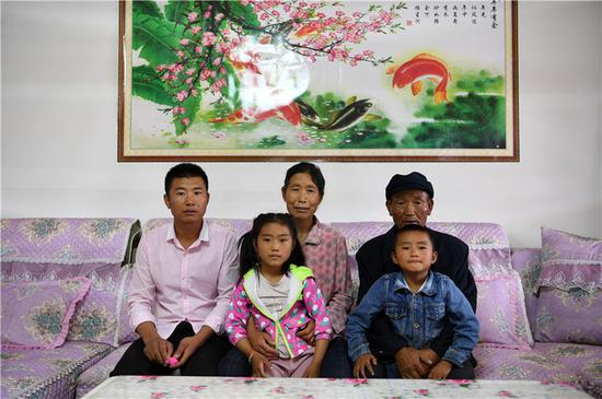 　在武威市古浪县黄花滩生态移民区富民新村，村民李应川（右一）和家人合影留念（8月22日摄）。新华社记者 范培珅 摄