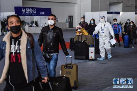  3月17日，入境人员在工作人员带领下离开新国展集散地，乘坐转运车辆。 新华社记者 彭子洋 摄