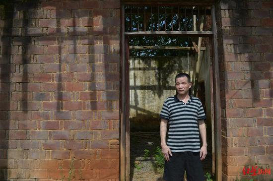 ▲张玉环站在老屋前