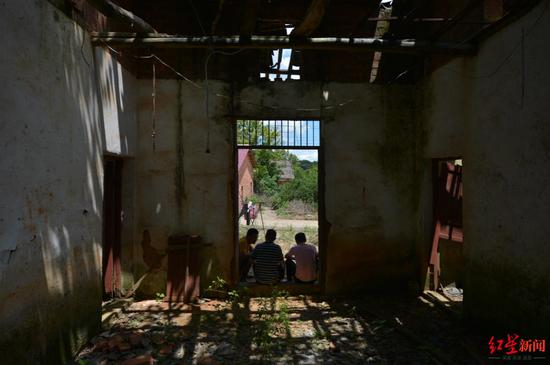  ▲张玉环和两个儿子坐在老屋门槛上谈心