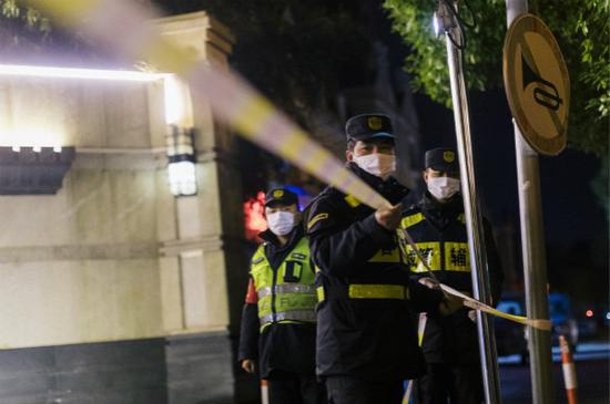 　　图说：4日深夜，城管队员将警戒线撤去。自5日零时起，明天华城小区正式降为低风险区域。萧君玮 摄（下同）
