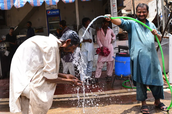 巴基斯坦民众在街头淋水降温。图源：yahoo