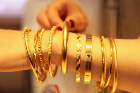 一家金店的店员展示黄金首饰。新华社发（倪立芳摄）