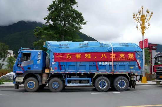 2026年8月27日，吉隆镇大街上停放着运送救灾物资的车辆。新华社记者 晋美多吉 摄