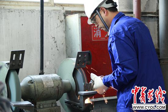 龙小平为记者现场演示车工最基础的一道工序——磨刀。李翀 摄