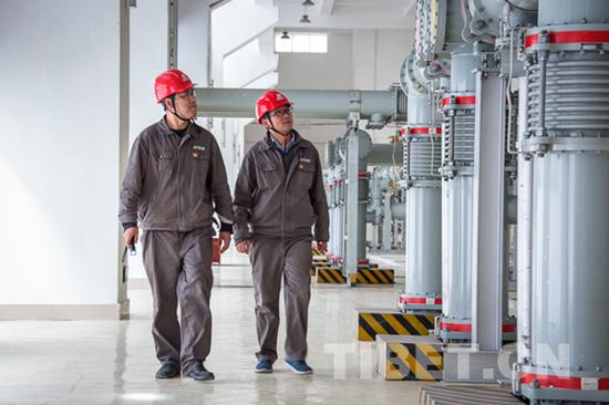 图为刘伟（左一）和同事在巡检设备。