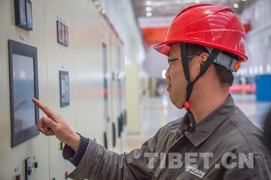 图为刘伟在调试设备。