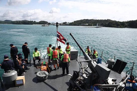 △ 泰国的救援人员在军舰的甲板上待命准备。