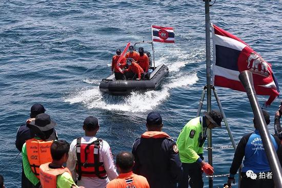 △ 事发地点的救援快艇驶向军舰，向军舰运送打捞的物品。
