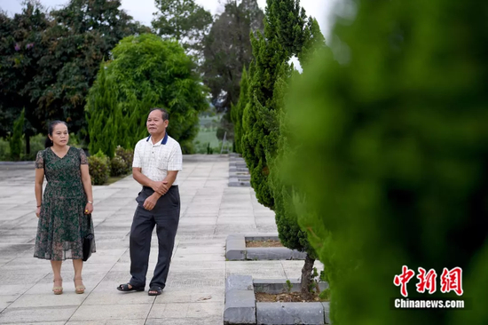 钮本同向游人介绍墓园情况。俞靖 摄