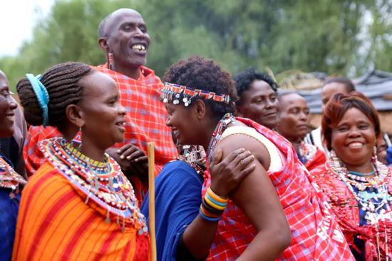 2018年6月4日，在肯尼亚南部边境恩度埃特村，马赛族村民热情欢迎妮丝的到来。新华社记者王腾摄