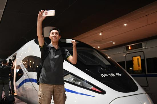 2018年9月23日，广深港高铁全线开通，搭乘G5711次高铁列车前往香港西九龙站的乘客在深圳北站拍照留念。