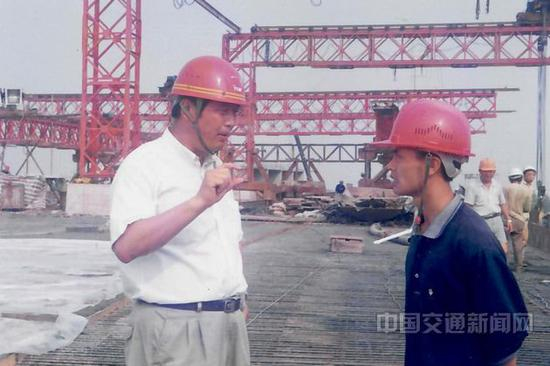 林鸣（左）在施工现场指导工作。