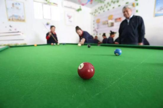 职业技能教育培训中心娱乐室，女学员正在打台球（图片来源环球时报）