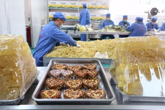 职业技能教育培训中心食品厂的工人们正在分装食品（图片来源环球时报）