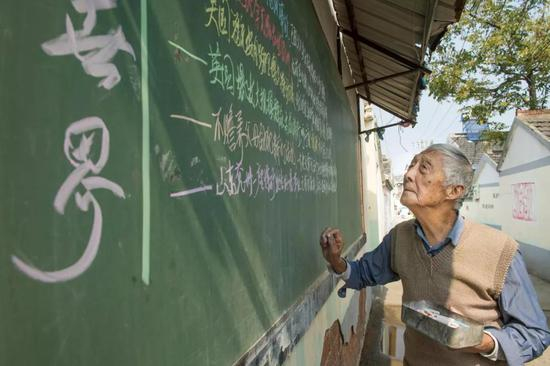 叶连平老师利用村口的黑板办简报，让村民们了解国际国内大事。