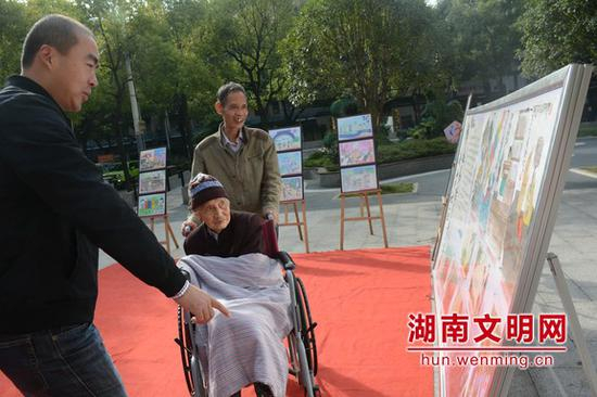 一位66岁的老人推着83岁的母亲观展。记者 彭团 摄