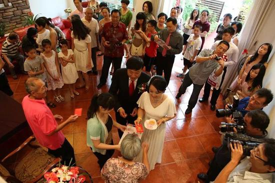 △ 2012年，上海，新婚夫妇向长辈敬茶。