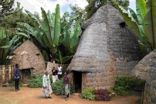 都则族村民在房前聊天
