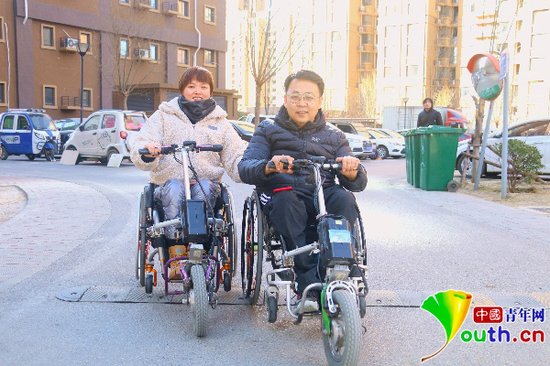 杜鹏和李春宏在小区划着轮椅并排而行。中国青年网记者李慧慧　摄