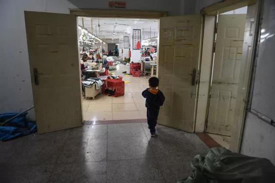 聪聪在车间门口等爸爸妈妈下班。