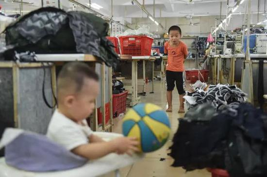 欧春鸿在观看刚满1岁的阿宝玩皮球。