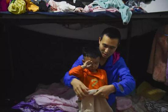 在工人宿舍，睡眼惺忪的聪聪在父亲黄海龙的帮助下穿衣服，准备去幼儿园。