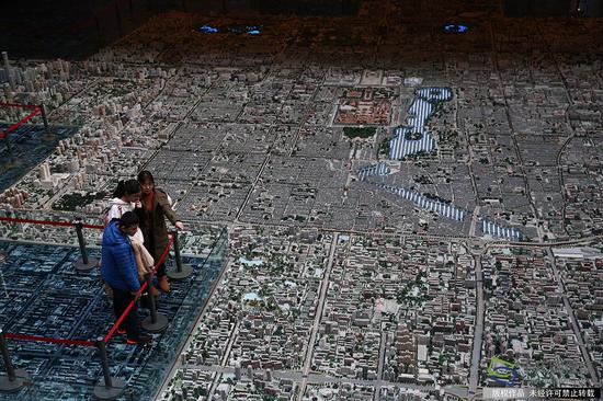 2月21日，市民在北京市规划展览馆参观北京城市规划沙盘模型（图片来源：tuku.qianlong.com）。千龙网记者 万小军摄
