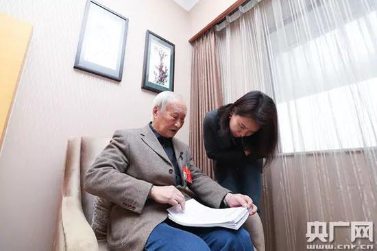  王家骐向记者展示本次大会准备提交的建议与议案（央广网记者 韩靖 摄）