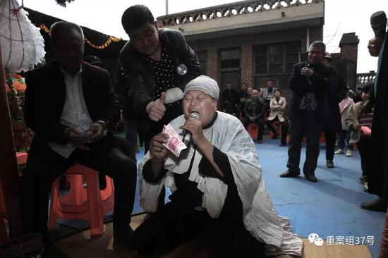 　▲三平跪在灵前哭唱，主家送上赏钱后对其伸出大拇指表示称赞。&nbsp;&nbsp; &nbsp; 新京报记者 尹亚飞 摄