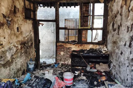 着火房间被烧得面目全非，置物柜中还残存着两个电瓶充电器。摄影/黄孝光