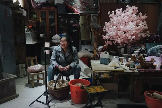 　　2019年4月15日，山东省菏泽市单县朱楼村，朱之文的妻子李玉华在直播剥花生。新京报记者 郑新洽 摄