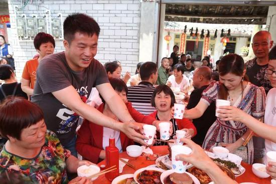 　　2019年5月14日，四川崇州市三江镇王桥村。王永福正在给前来道喜的亲朋敬酒。新京报记者 尹亚飞 摄